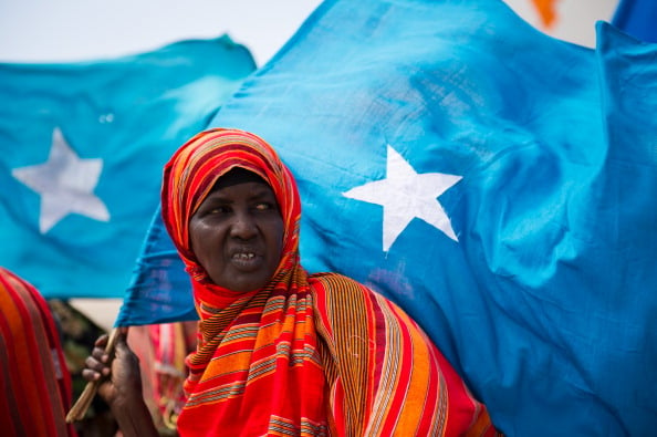 A woman holds the Somali flag