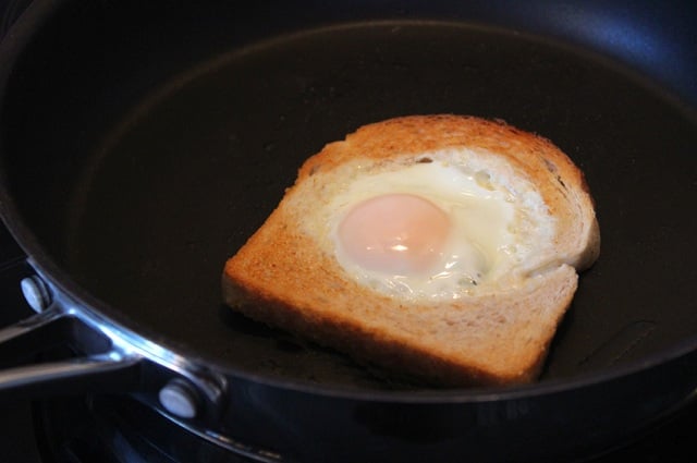 Fried egg in a piece of bread in a skillet
