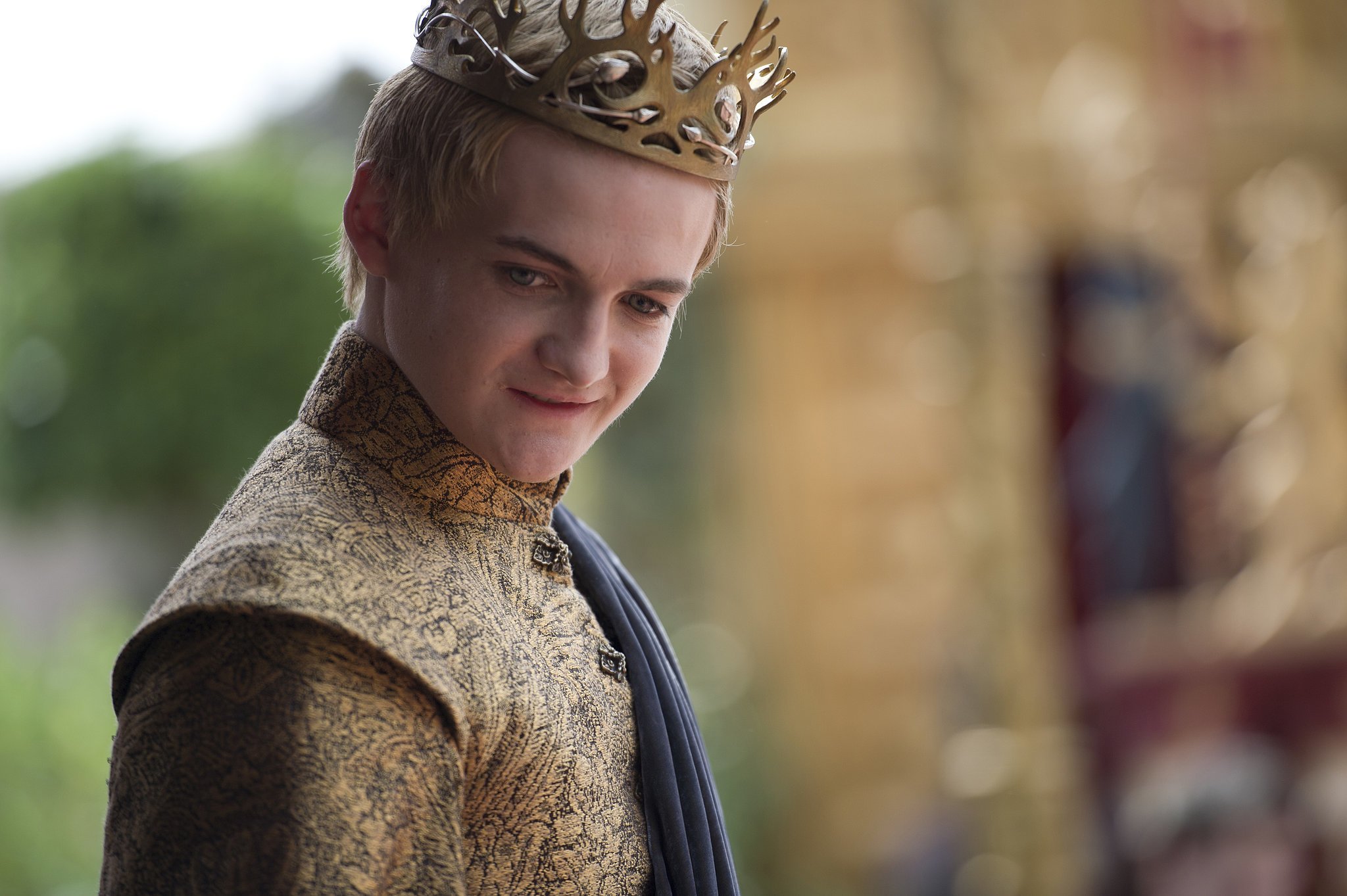 Joffrey stands, smirking, as he wears his crown, in a scene from 'Game of Thrones.'