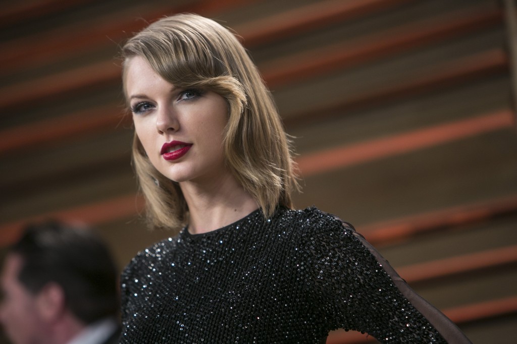Taylor Swift posing in a black dress