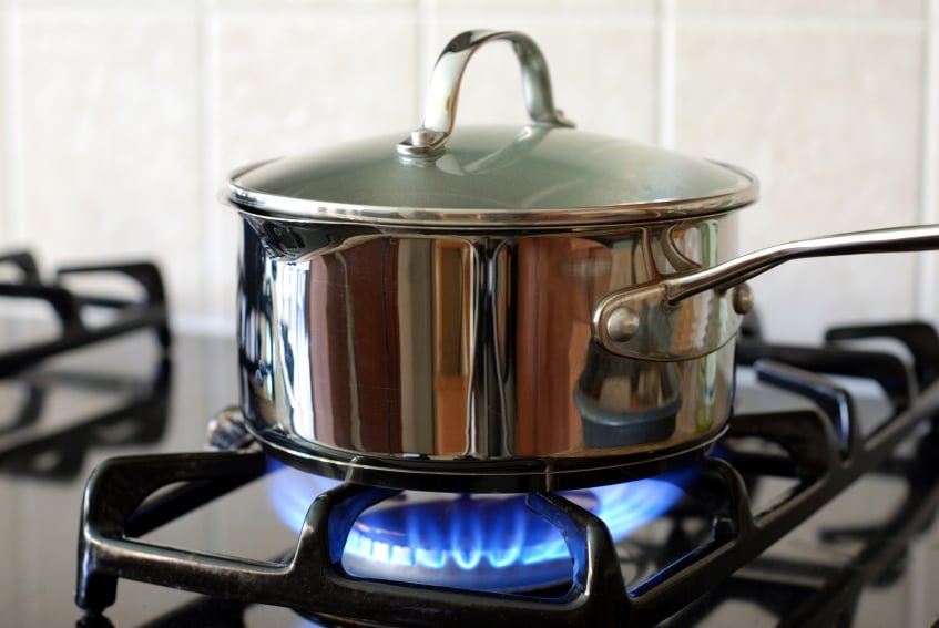 A pot boils on a gas counter