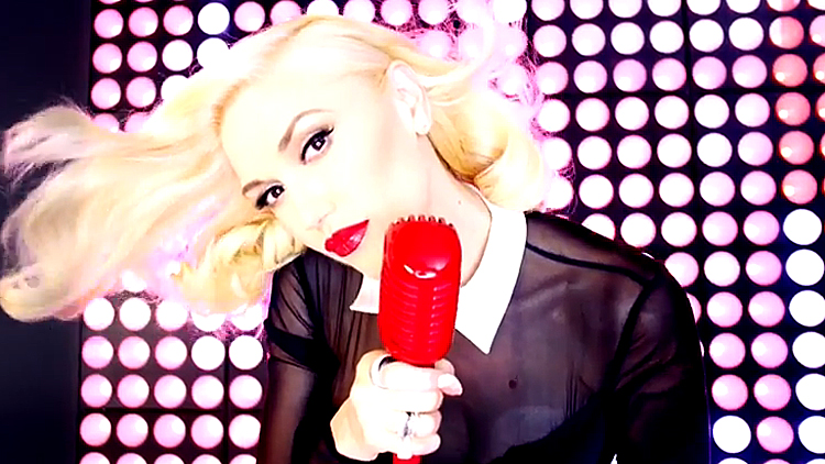 Gwen Stefani with a mic performing 