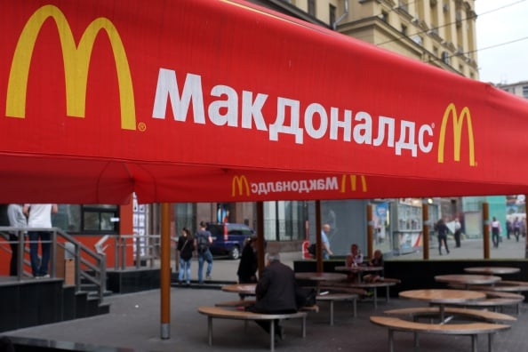 People sit on the terrace of a closed McDonald's restaurant, the first to be opened in the Soviet Union in 1990, in Moscow on August 21, 2014. Russian authorities shuttered four Moscow McDonald's due to alleged sanitary violations on August 20, 2014, including a restaurant that once symbolised reviving Soviet-US ties, as tensions sizzled over Ukraine. The announcement comes in the wake of Russian bans on US and EU food imports in response to Western sanctions over Moscow's perceived backing for rebels in eastern Ukraine. (Photo by Alexander Nemenov/AFP/Getty Images)