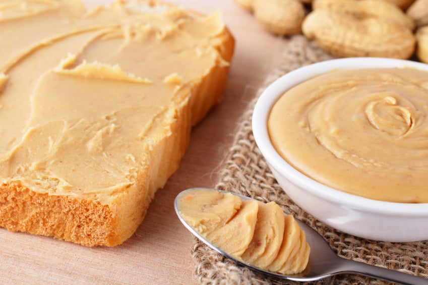 Spreading peanut butter on bread | iStock.com