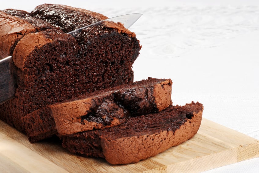 slicing a piece of rich, chocolate pound cake
