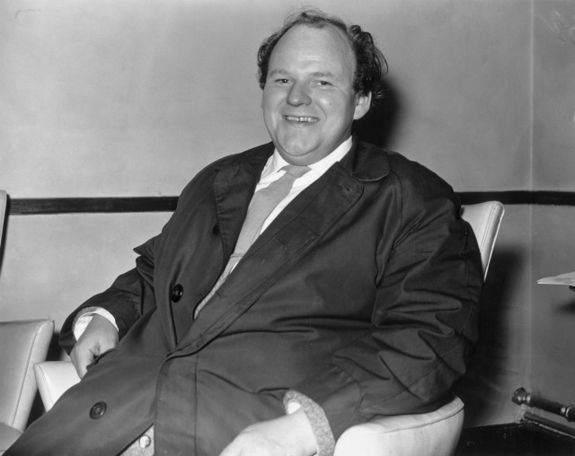 Roy Kinnear sitting on a chair laughing