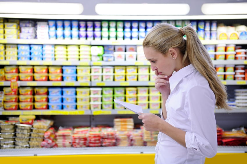woman looking at grocery list at grocery store