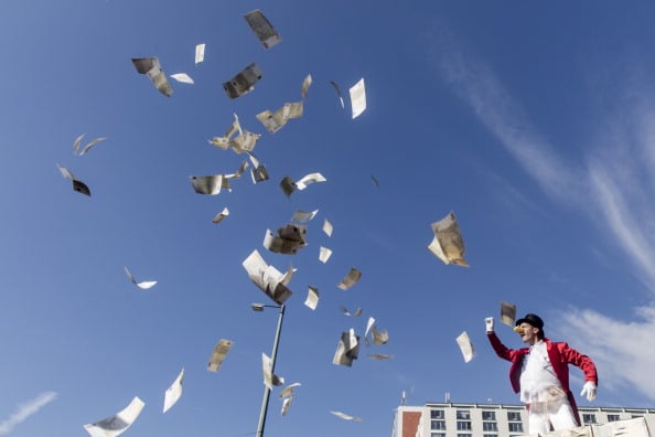 A rich man tosses money into the air