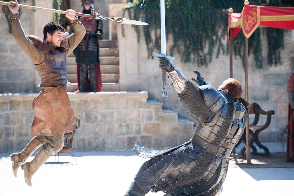 Oberyn Martell with spear in hand, jumps at a full armored Gregor Clegane, who's falling backwards to the ground