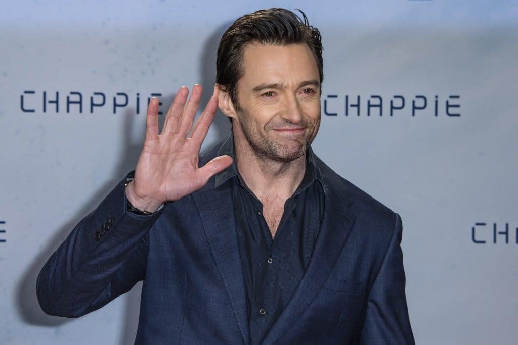 Hugh Jackman waves on the red carpet at the premiere of Chappie