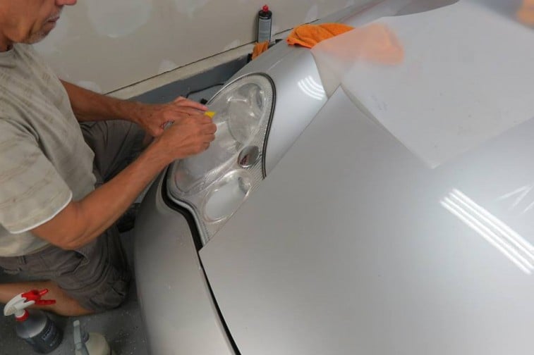 Man cleaning car headlight