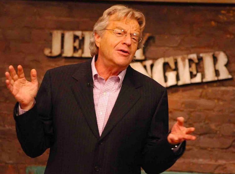 Jerry Springer gestures with his hands while on the set of The Jerry Springer Show