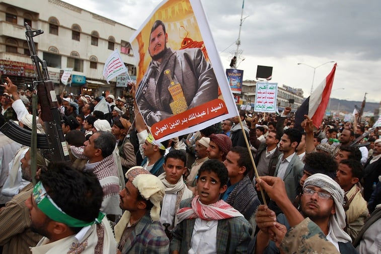 Yemeni supporters of the Shiite Huthi militia hold a portrait the movement's leader, Abdul-Malik al-Huthi 