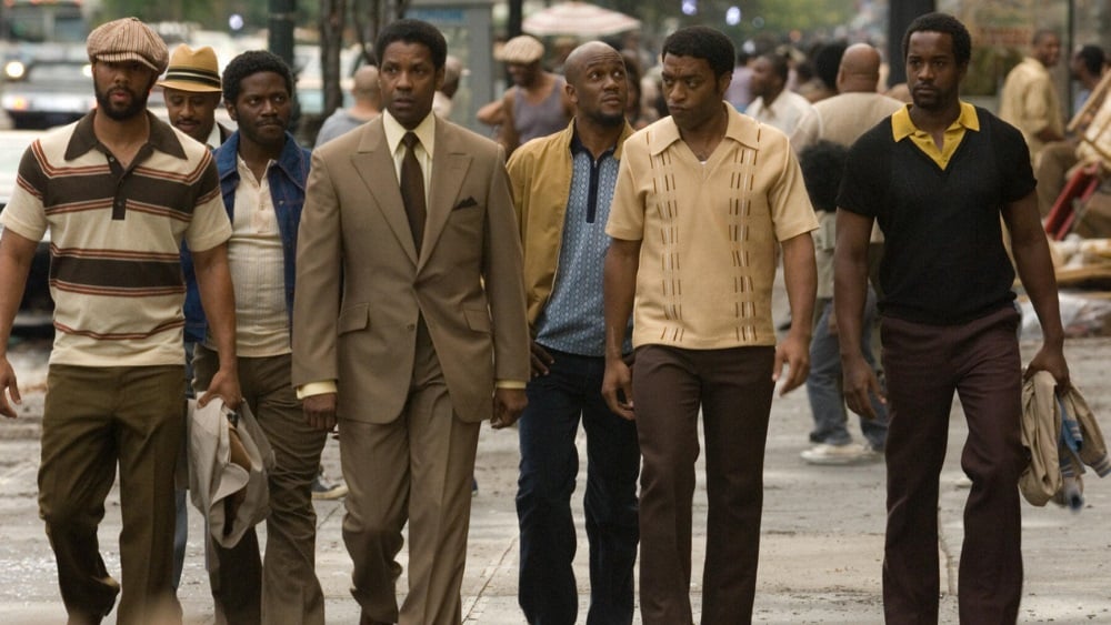 Frank Lucas (Denzel Washington) walks on a sidewalk in New York flanked by his business associates.
