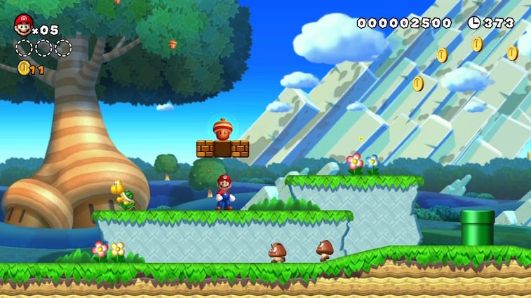 Mario stands above Goombas and uncorks an acorn from a question block.