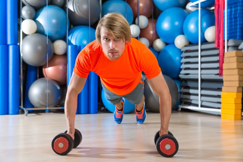 man using dumbbells to perform a plank exercise