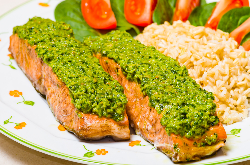 salmon topped with pesto served with rice and a salad