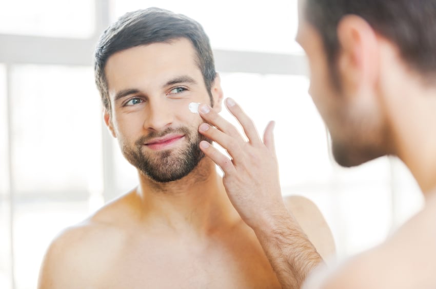 a man applying moisturizer