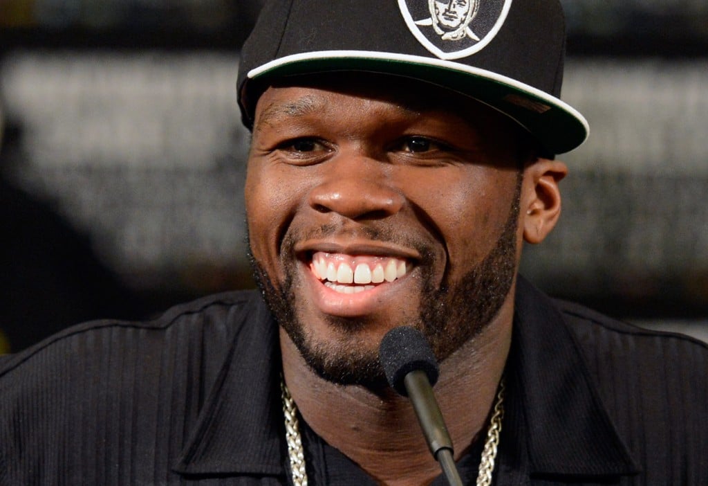 50 cent smiles while speaking into a microphone