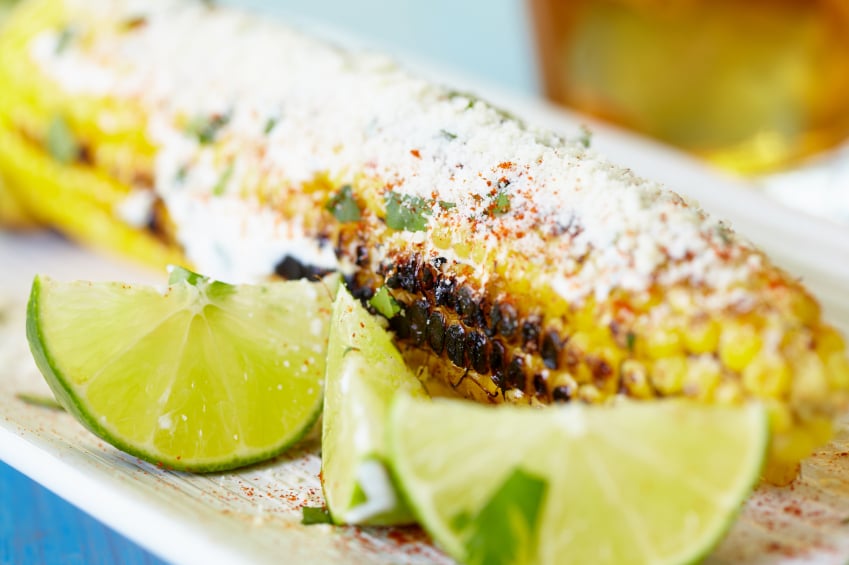 sweet corn on the cob with cheese and lime