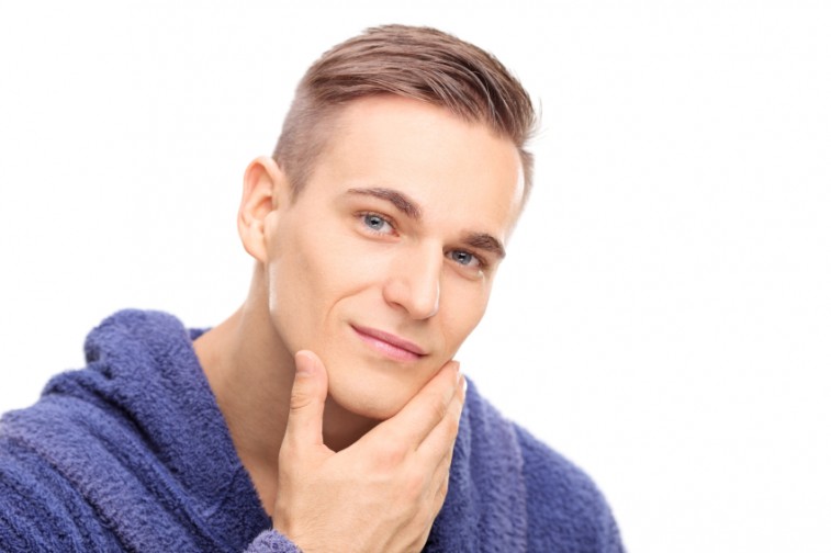 Young man checking the skin on his face, shaving, grooming