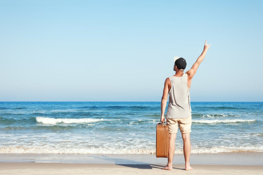 a man on the beach with a suitcase