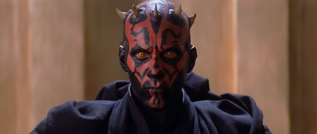 Darth Maul, wearing black robes, and looking intensely into the camera
