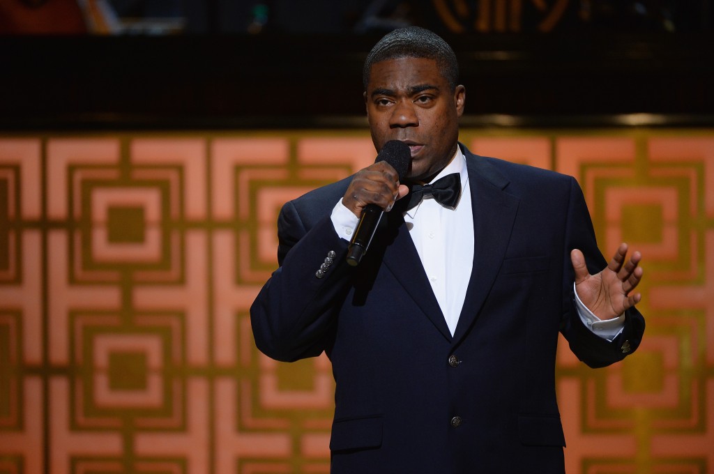 Tracy Morgan holds a microphone while speaking at an awards show.