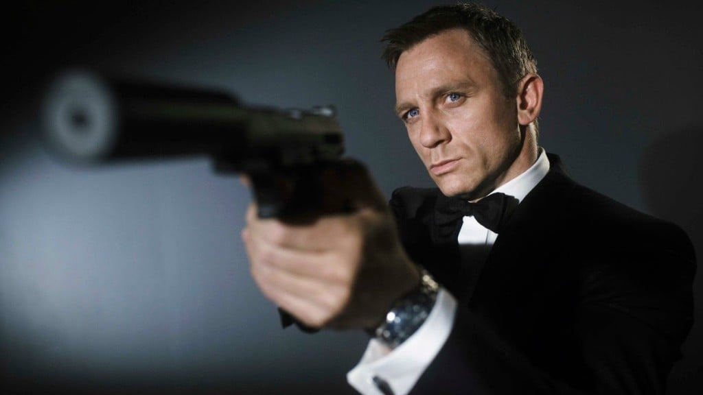 Daniel Craig holds up a gun while wearing a tux as James Bond 