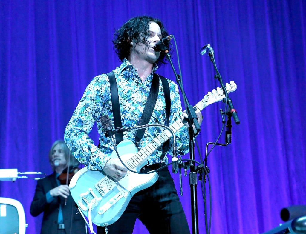 Jack White singing on stage with his electric guitar