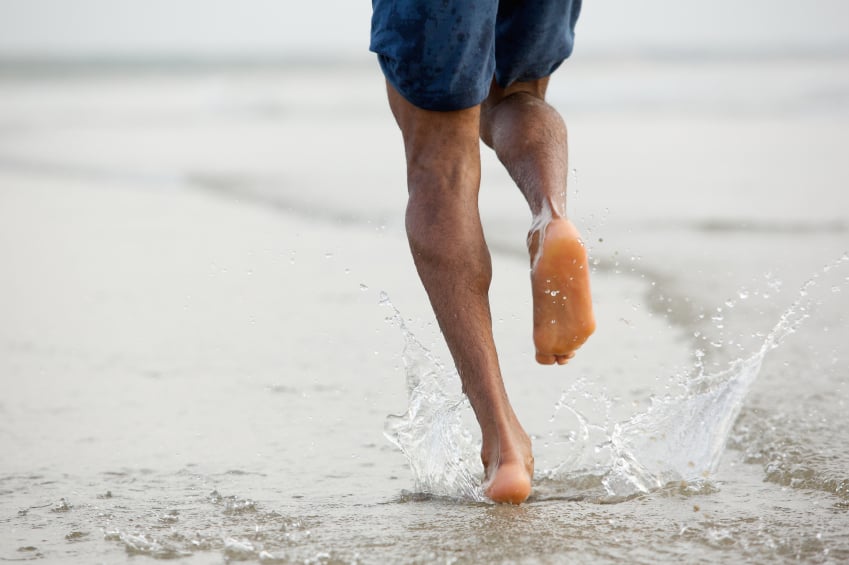barefoot man running through water