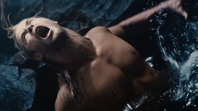 A shirtless short in a pool of water screaming, while looking upwards