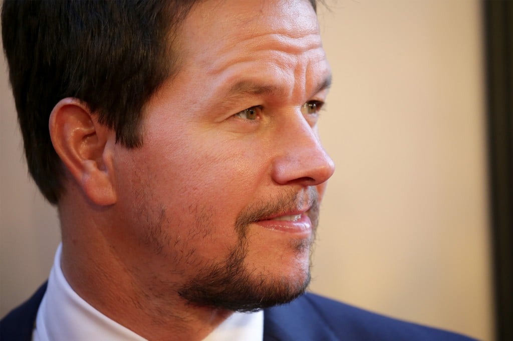 Mark Wahlberg wearing a blue suit, looking to the right of the frame