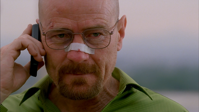 Bryan Cranston as Walter White holding a cell phone to his ear with a bandage on his nose on Breaking Bad