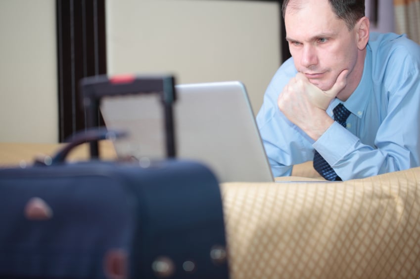 man on computer in a hotel room
