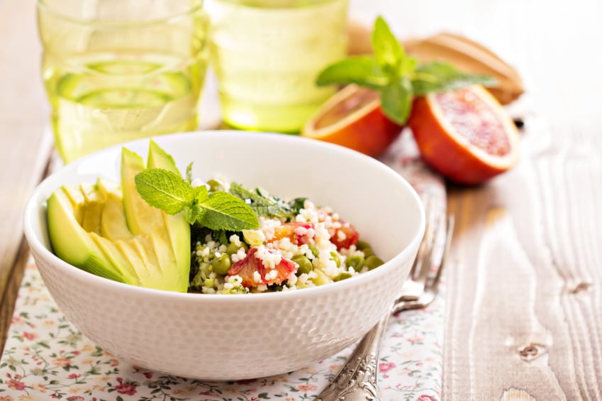 bowl of couscous with herbs and sliced avocado