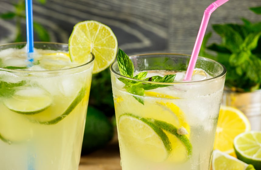 two glasses of a lemon-lime cocktail with a straw