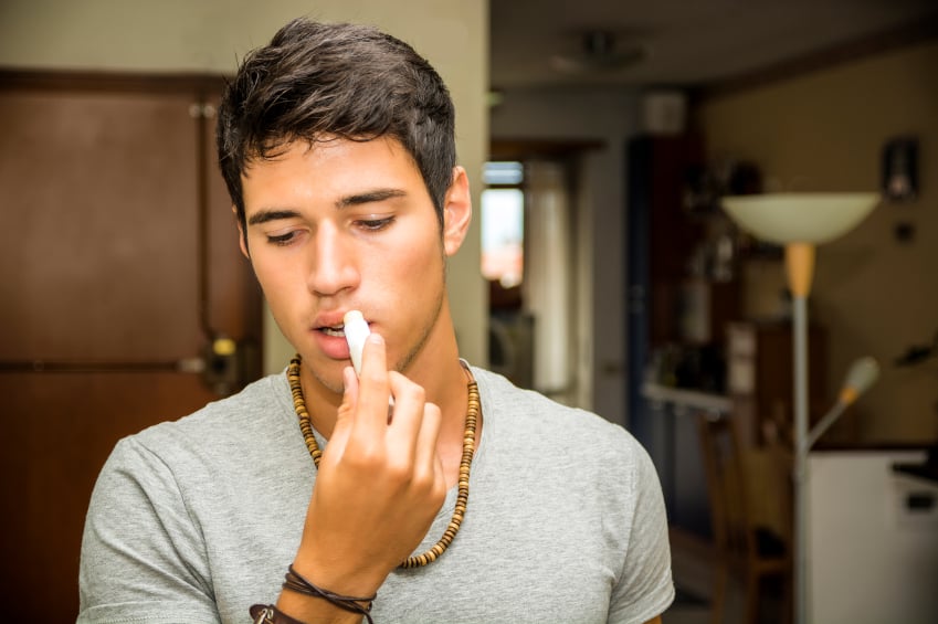 man applying lip balm