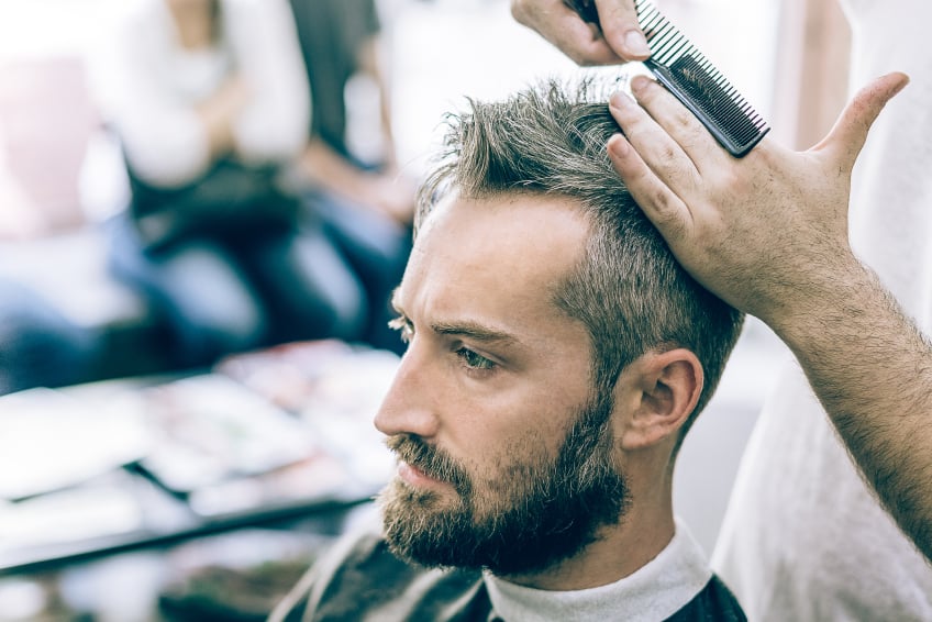 young man with beard having haircut