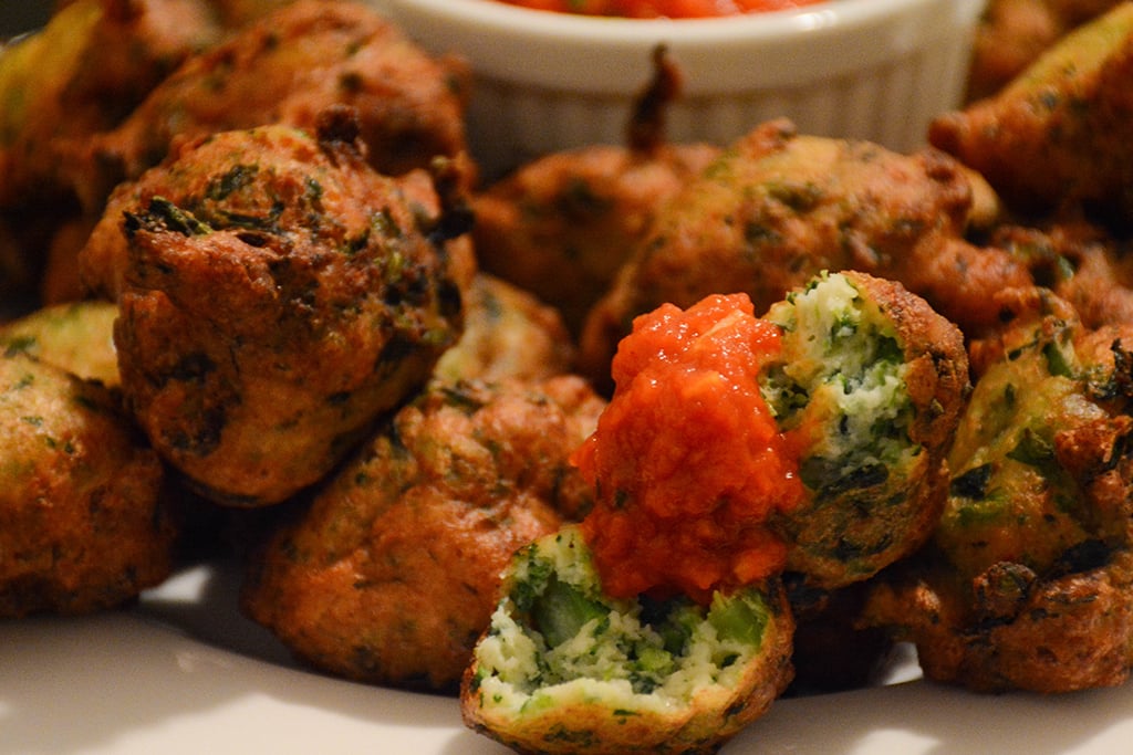 close shot of broccoli rabe-ricotta fritters with tomato-basil sauce