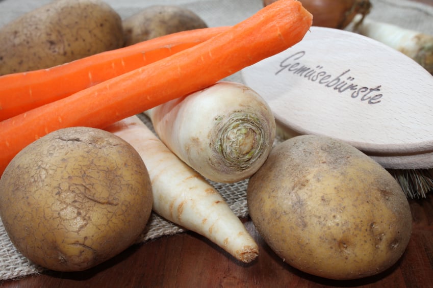 assorted root vegetables including parsnips, potatoes, and peeled carrots