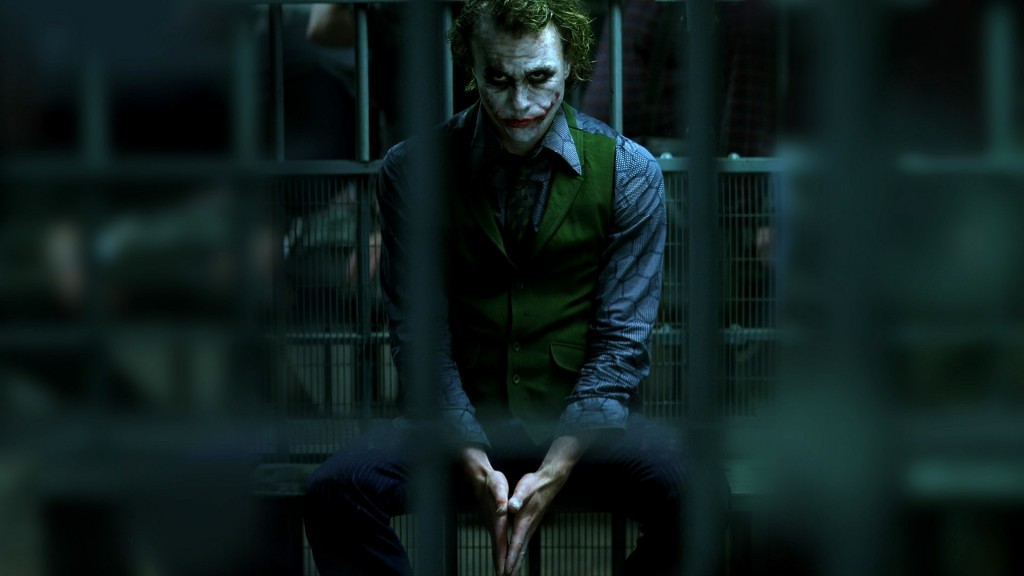 Heath Ledger as the Joker, sitting in a jail cell with his hands together