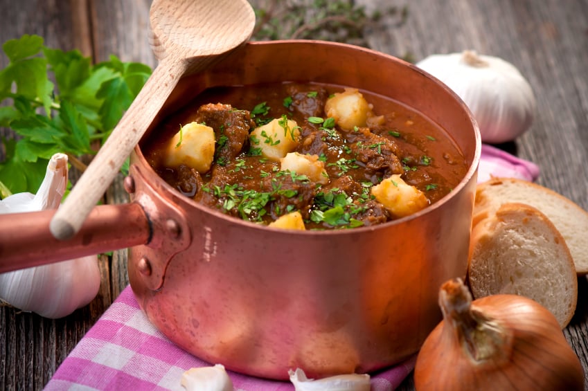 goulash stew in a copper pot sprinkled with parsley