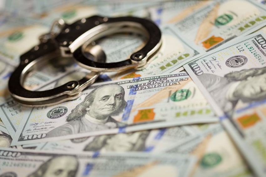 handcuffs on pile of money