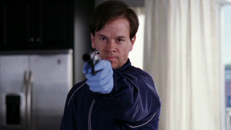 Mark Wahlberg is holding up a gun.