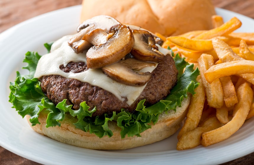 burger with mushrooms and swiss cheese without the top bun and a side of oven fries