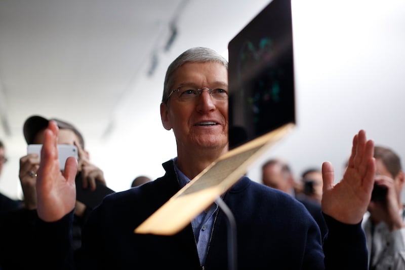 Tim Cook stands in front of a MacBook