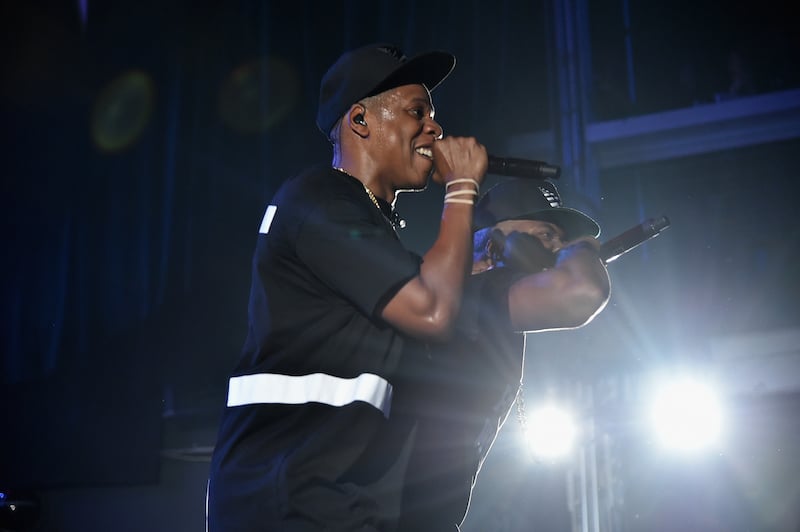 JAY-Z holds up a microphone on stage