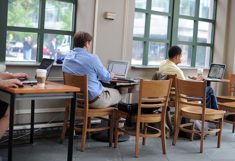 People use their laptops at a Starbucks that offers free WiFi