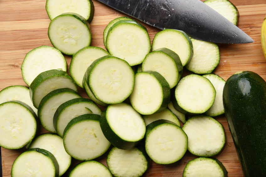 Sliced zucchini with a whole zucchini